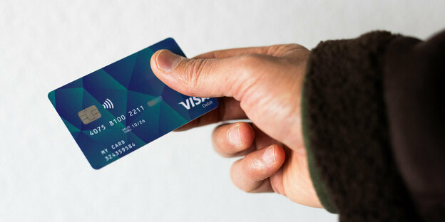 A payment card in a hand.