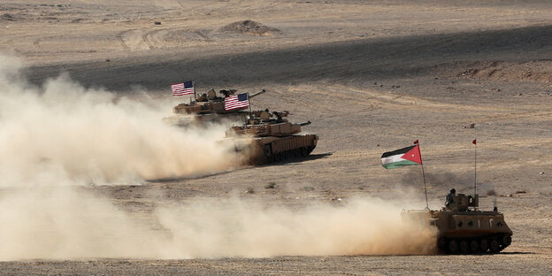 Tanks cross the desert.