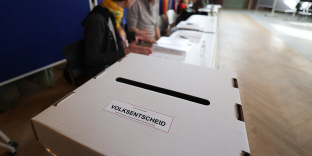 Das Bild zeigt eine Wahlurne mit der Aufschrift "Volksentscheid"