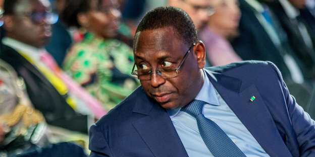 Macky Sall looks to the right.