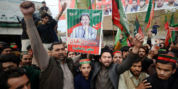 Pakistani protesters holding a poster of politician Imran Khan
