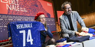 Mariette Rissenbeek und Carlo Chatrian halten ein Triko mit der Aufschrift Berlinale in die Kamera.