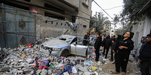 People in Gaza look at the rubble outside a house in the city of Rafah in the Gaza Strip.