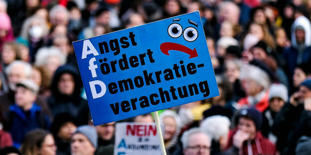 A protest sign is held during a demonstration against right-wing extremism and the AfD.