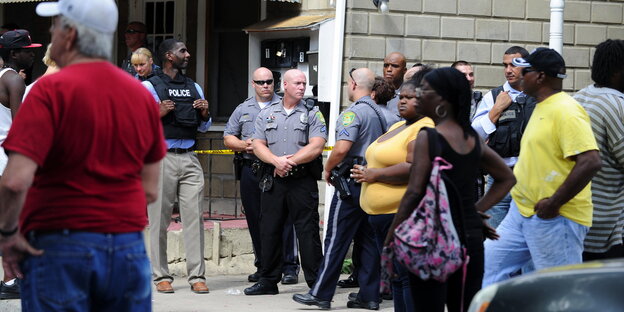 Menschen und Polizisten stehen am Tatort in Dover, Delaware Menschen und Polizisten stehen am Tatort in Dover, Delaware