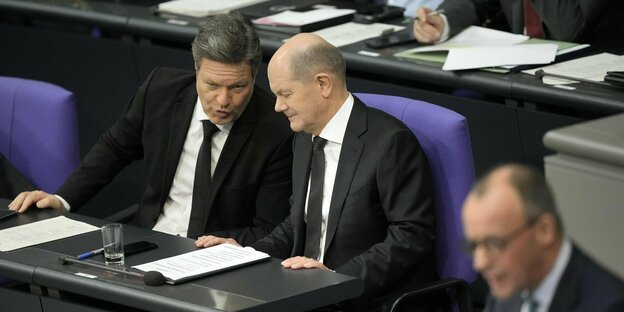 Habeck and Scholz whisper as Merz speaks in the Bundestag