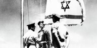 Drei Soldaten hissen die israelische Flagge.