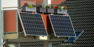 Solarmodule für ein Balkonkraftwerk hängen an einem Balkon.