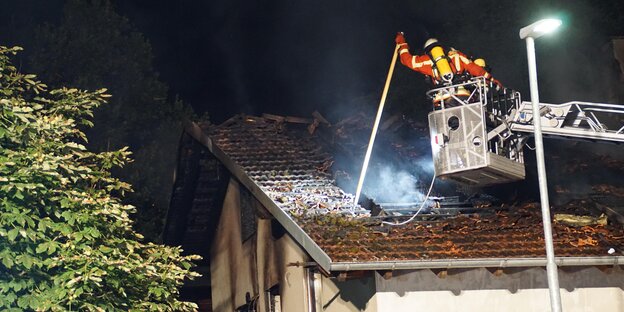 Feuerwehrmensch löscht Brand von oben Feuerwehrmensch löscht Brand von oben