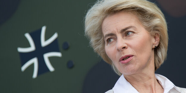 Ursula von der Leyen vor einem Hoheitszeichen der Bundeswehr.