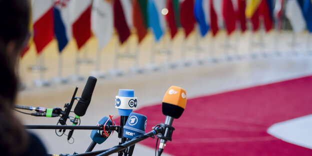 Microphones in front of flags.