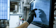 In der Produktionsanlage der Firma Meyer Burger zeigt eine Hand auf ein Solarmodul