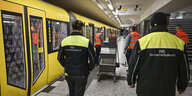 Reinigungskräfte und Mitarbeiter eines Sicherheitsdienstes gehen bei der Vorstellung eines Pilotprojektes der Berliner Verkehrsbetriebe (BVG) zur Bedeutung von Sicherheit und Sauberkeit durch den U-Bahnhof Hermannstraße