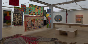 Blick in die Ausstellung "Soft Power", mit textilen Werken auf dem Boden, schwebend und an den Wänden
