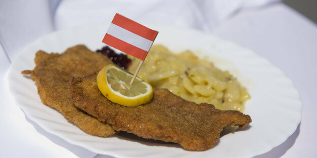 A juicy schnitzel with lemon and French fries.