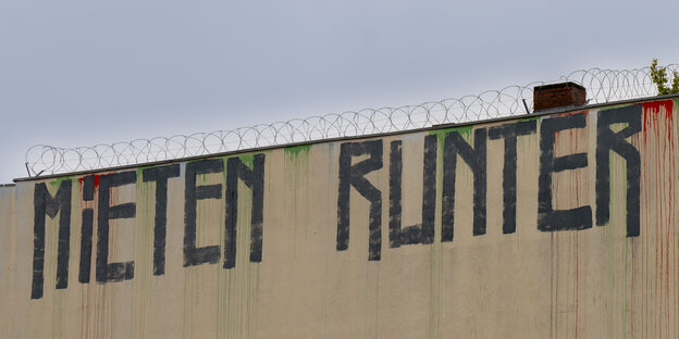 Der Schriftzug «Mieten runter» ist an der Wand eines Miethauses mit Graffiti beschmiert.