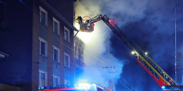 A firefighter puts out the fire in an apartment building in Solingen from a rotating ladder