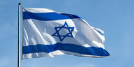 Eine israelische Flagge flattert im Wind vor blauem Himmel