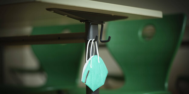 An FFP-2 mask hanging from a school desk