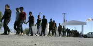 Migranten aus Syrien laufen hintereinander in einem Flüchtlingscamp nahe Nikosia