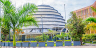 Das Kongresszentrum in Kigali, eine gläserne Kuppel. Davor Palmen.