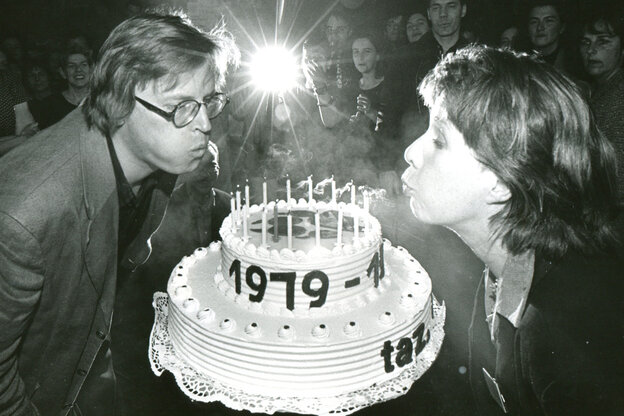 schwarz-weiß Bild: zwei taz Redakteure pusten Kerzen auf einer Torte aus, am Rand ist 1979 zu lesen