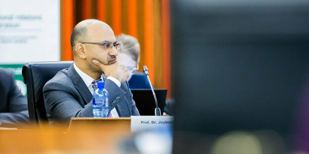 The director of the University of Cologne, Joybrato Mukherjee, sitting on a podium