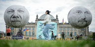 Zwei große Ballons, die Kanzler Scholz und Finanzminister Lindner zeigen, im Hintergrund ein nicht lesbares Plakat und der Bundestag