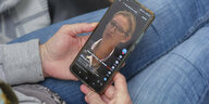 Frau hält ein Mobiltelefon auf dessen Display auf der Plattform TikTok ein Video der AFD Politikerin Alice Weidel zu sehen ist.