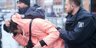 Raphael Thelen wird mit heruntergedrücktem Kopf von zwei Polizisten abgeführt