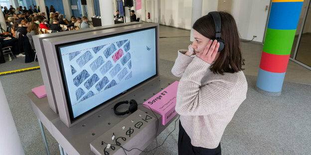 Eine Person am Computer in einer Ausstellung.