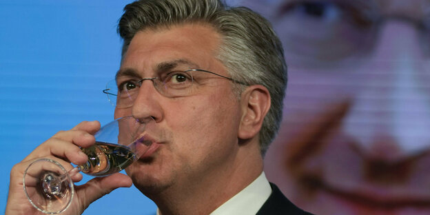 Prime Minister Andrej Plenković drinks from a glass of champagne