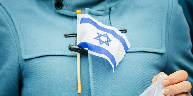 The flag of Israel in front of a sweater.