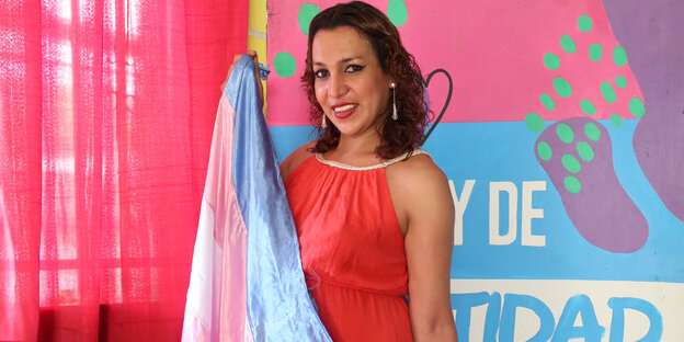 Transfrau Fabiola Yescos posiert mit einer Fahne
