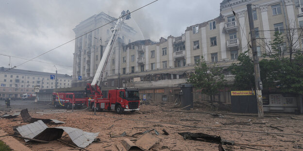 Feuerwehrleute löschen den Brand eines teilweise zerstörten Wohnhauses