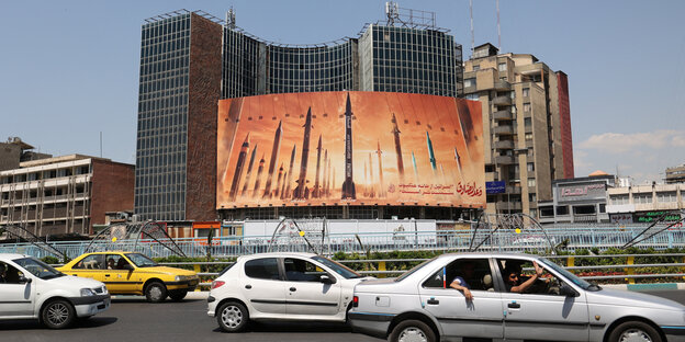 An anti-Israel poster with an image of Iranian missiles stands on a street in Tehran.