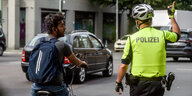 Ein Fahrradfahrer wird von einem Polizisten angehalten