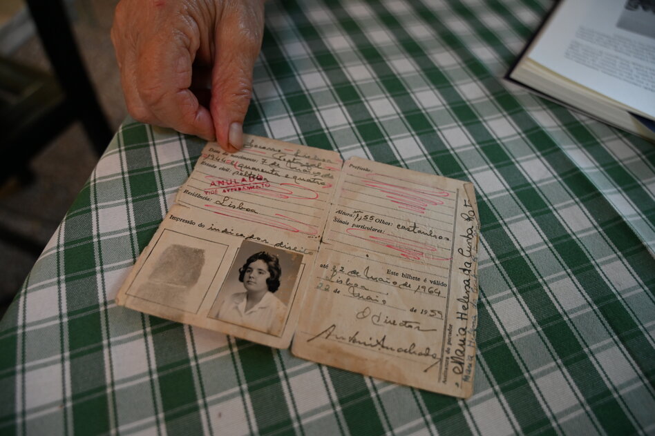 Ein altes Dokument mit Frauenportrait liegt auf einem grün karierten Tischtuch