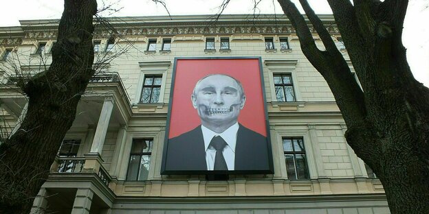 Ein großes Plakat mit dem Foto von Wladimir Puti, das ihn mit gefletschten Zähnen und Totenkopf Anmutung zeigt, hängt an einem Gebäude in Riga