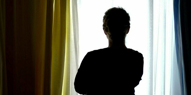 Silhouette of a woman standing at a window