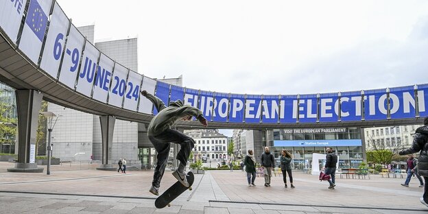Skateboardfahrer vor einem Transparent zur EU-Wahl in brüssel