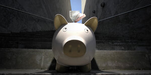 Sparschwein mit Geldscheinen, die oben aus dem Sparschlitz rausgucken