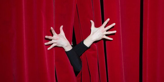 Hands in front of a red curtain