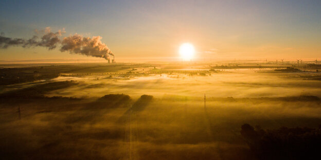 Strahlende Morgensonne, am Horizont ein Kohlekraftwerk