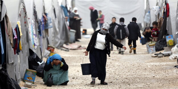 Flüchtlinge vor ihren Zelten in einem Flüchtlingscamp Flüchtlinge vor ihren Zelten in einem Flüchtlingscamp