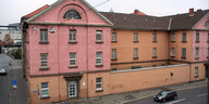 Ein rosa- und orangefarbenes Gebäude mit Gitterfenstern