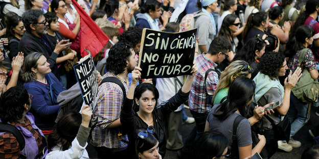 At a demonstration in Buonos Aires, a student holds a sign with the inscription 