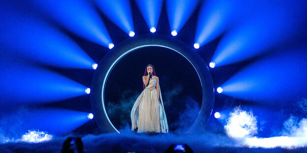 Sängerin Eden Golan steht auf der Bühne in einem weißen Kleid