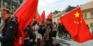 Menschen mit chinesischen Fahnen am Straßenrand