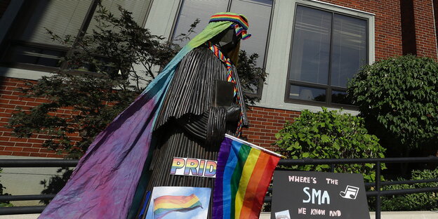Geistliche Statue in Portland, Oregon, mit der Regenbogenfahne geschmückt Geistliche Statue in Portland, Oregon, mit der Regenbogenfahne geschmückt